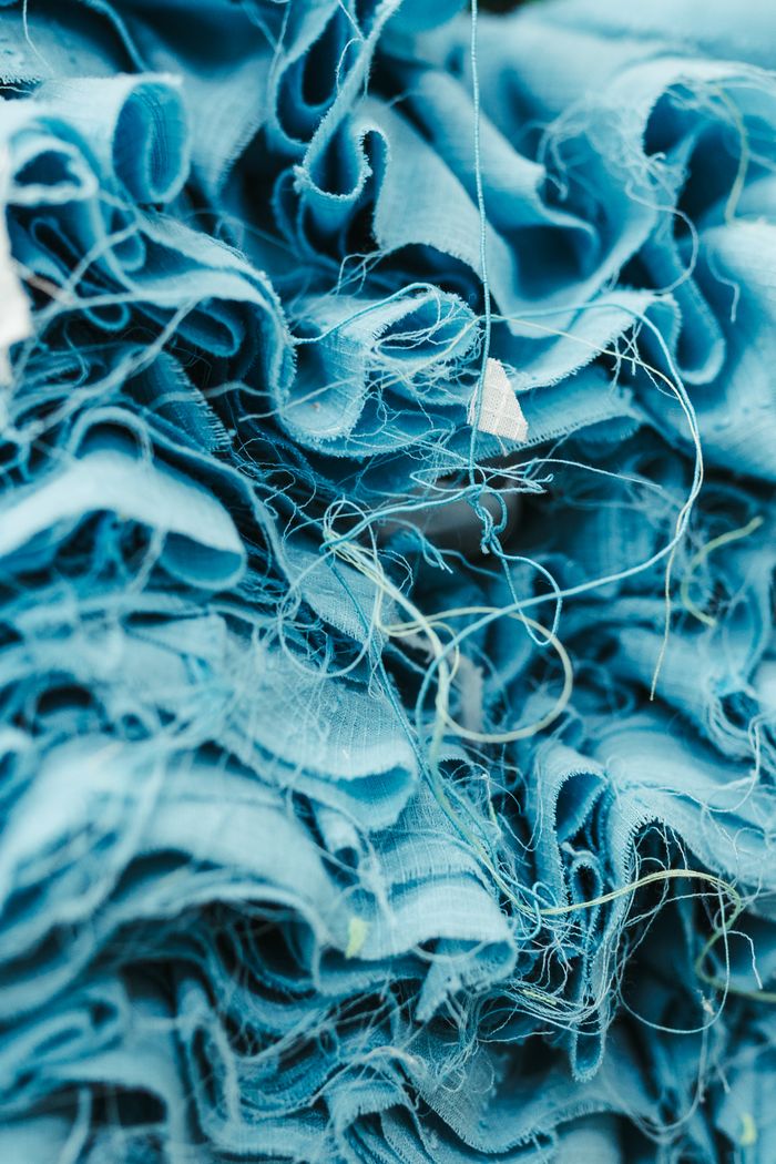 An artistic close-up of blue fabric showcasing intricate textures and threads.