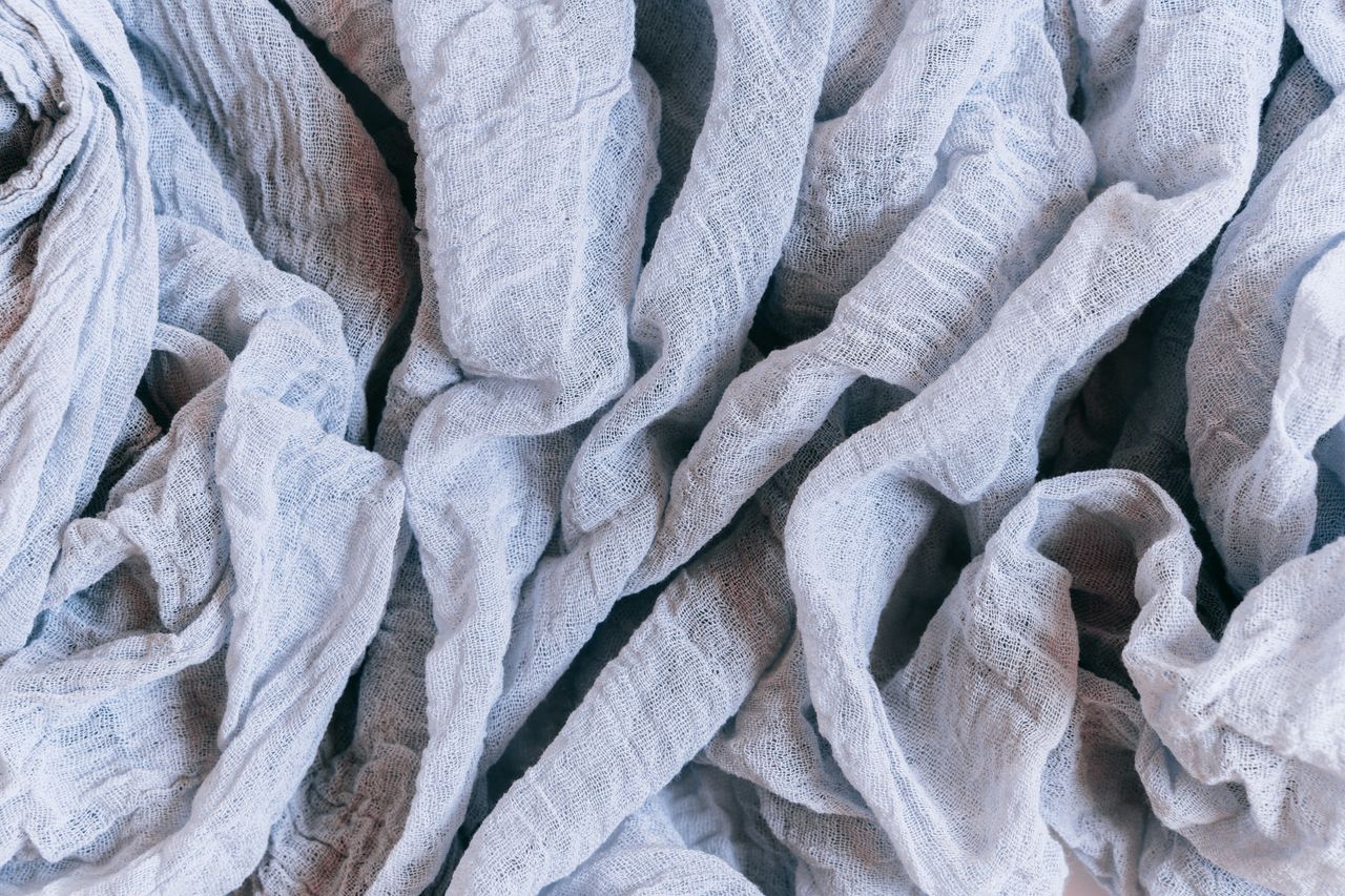 A detailed close-up of crumpled linen fabric showcasing its intricate texture and soft material.